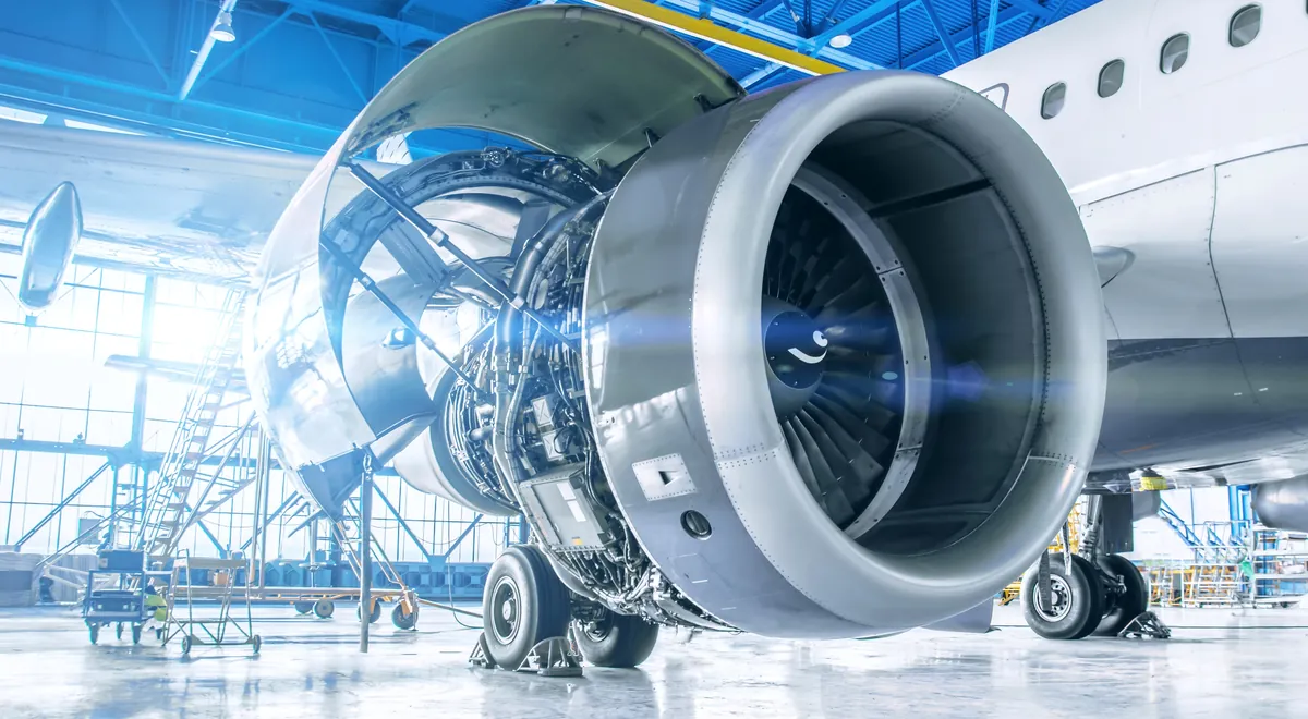 Jet engine with its nacelle open in a maintenance hangar
