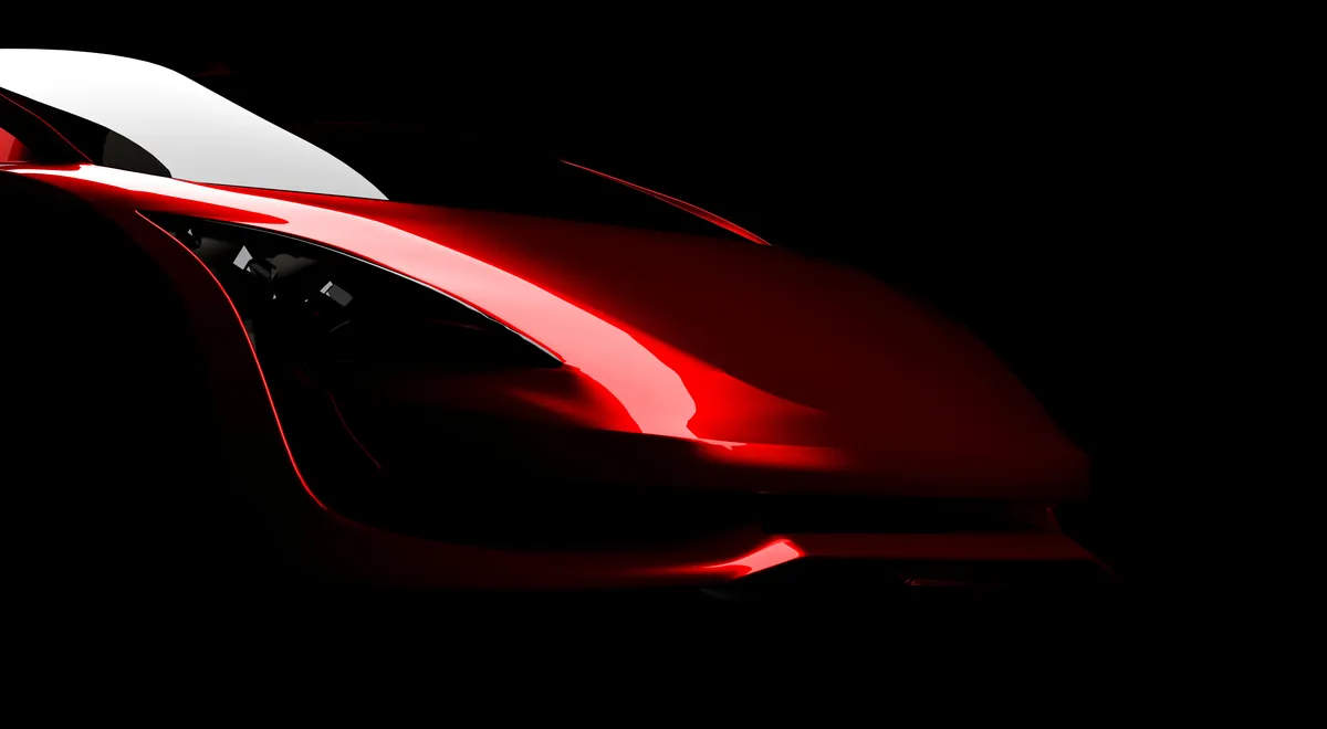 Red sports car emerging from a dark background
